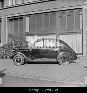 Ford V8 vor der Firmenzentrale der Ford Werke in Köln Niehl, Deutschland 1930er Jahre. Una Ford V8 nella parte anteriore del tedesco Ford sede a Colonia, Germania 1930s. Foto Stock