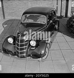 Ford V8 vor der Firmenzentrale der Ford Werke in Köln Niehl, Deutschland 1930er Jahre. Una Ford V8 nella parte anteriore del tedesco Ford sede a Colonia, Germania 1930s. Foto Stock