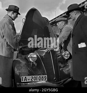 Fachgespräche mit dem Mechaniker am eines motore Ford Eifel, Deutschland 1930er Jahre. Esperto di discussione con il garage manager presso il cofano di una Ford Eifel, Germania 1930s. Foto Stock