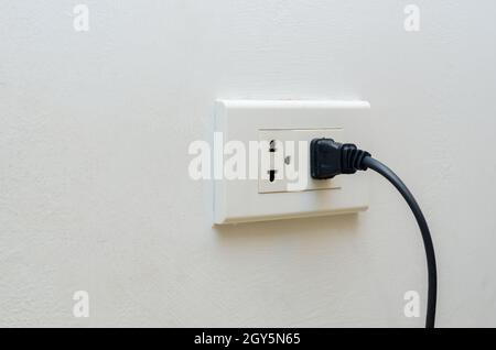 Uscita a mano risparmio energetico mano inserire la spina elettrica in uscita Foto Stock
