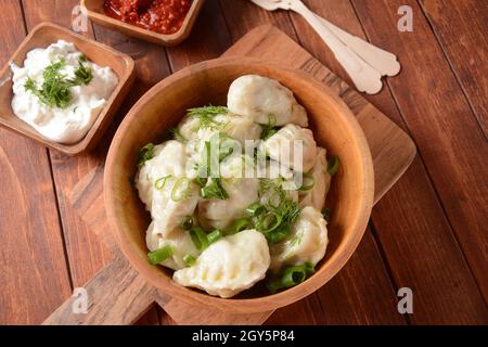 Gnocchi fatti in casa, cucina Dagestan, Kurze. I gnocchi si sussurrano con il ripieno Meet e la salsa calda adjika su un piatto Foto Stock