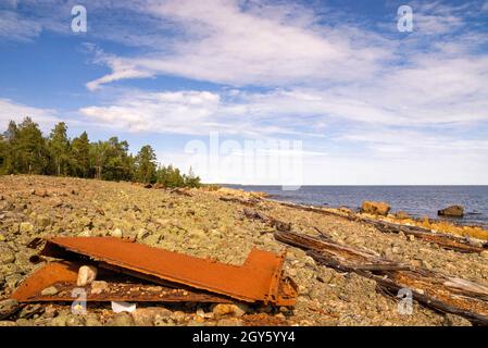 Resti arrugginiti di una nave su una spiaggia rocciosa lungo il Mar Bothnian sulla penisola di Hornslandet vicino alla città svedese Hudiksvall Foto Stock