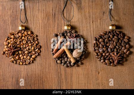La collezione di spezie aromatiche e i diversi chicchi di caffè come le palle di Natale a forma di fila. Allspice, bastoncini di cannella, chiodi di garofano, fagioli arabica tostati alla noce moscata Foto Stock