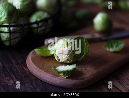 Vista ravvicinata di un germoglio brussel su un tagliere di legno. Foto Stock