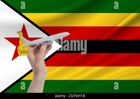 Aereo in mano con bandiera nazionale dello Zimbabwe viaggio in Zimbabwe. Foto Stock