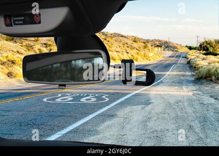 Guardando attraverso un auto dashcam telecamera montata su un parabrezza con vista sulla storica Route 66, con pavimentazione sign in California, Stati Uniti d'America Foto Stock