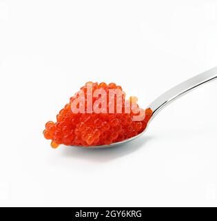 caviale fresco di salmone al chum rosso granato in cucchiaio metallico, fondo bianco, primo piano Foto Stock