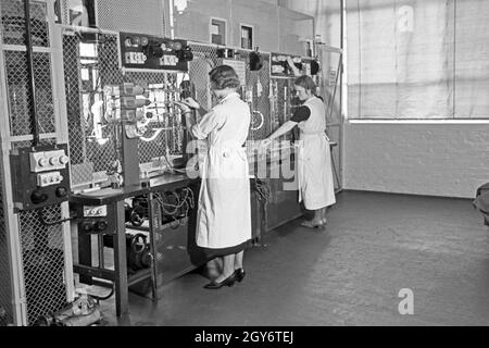 Mitarbeiterinnen bei der Produktion von Leuchtröhren, Deutschland 1930er Jahre. Personale femminile membri che producono tubi fluorescenti, Germania 1930s. Foto Stock