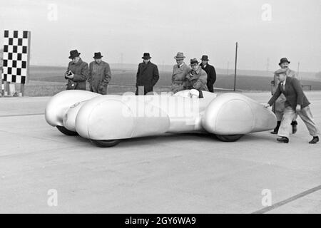 Vorsichtig wird der Mercedes Benz W 125 mit dem Rennfahrer Rudolf Caracciola am Steuer an den Start zum Weltrekordversuch geschoben, Deutschland 1930 Jahre. Con attenzione, la Mercedes Benz W 125 con Rudolf Caracciola all'interno è spinta all'inizio della prova record mondiale, la Germania anni trenta. Foto Stock