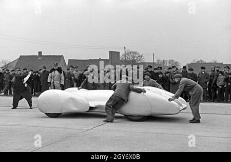 Vorsichtig wird der Mercedes Benz W 125 mit dem deutschen Rennfahrer Rudolf Caracciola am Steuer zum Start des Weltrekordversuchs geschoben, Deutschland 1930er Jahre. Attentamente il Mercedes Benz W 125 con il tedesco race driver Rudolf Caracciola interno viene spinto all'inizio del record del mondo di prova, Germania 1930s. Foto Stock