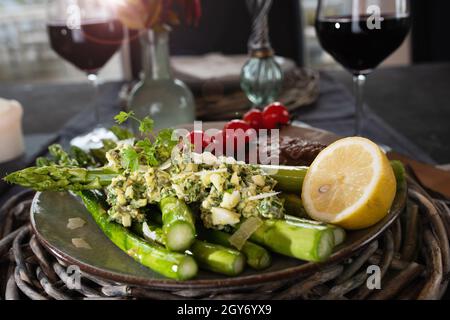 Asparagi verdi fritti disposti su un piatto. Cibo sano e gustoso. Sfondo di stile di vita per la gastronomia con breve profondità di campo. Foto Stock