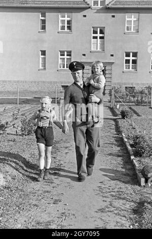 Ein Mann kommt mit zwei kleinen Kindern an der mano aus einem Haus auf der Halbinsel Hela in Ostpreußen, Deutschland 1930er Jahre. Un uomo con due bambini piccoli sulle sue mani che esce di casa a cellule Hela in Prussia orientale, Germania 1930s. Foto Stock