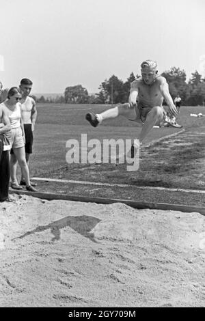 Übung im Weitsprung auf dem Sportplatz des KdF Sportheim Belzig in der Mark Brandenburg, Deutschland 1930er Jahre. Salto in lungo esercizio presso il campo sportivo dello sports club house a Belzig nel Brandeburgo, Germania 1930s. Foto Stock