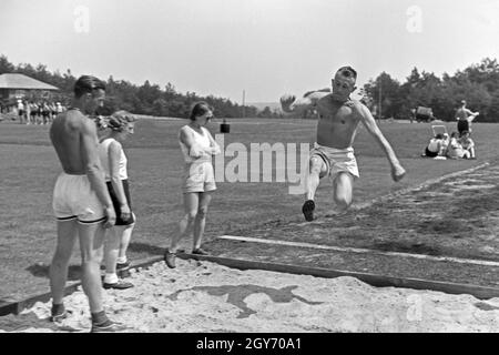 Übung im Weitsprung auf dem Sportplatz des KdF Sportheim Belzig in der Mark Brandenburg, Deutschland 1930er Jahre. Salto in lungo esercizio presso il campo sportivo dello sports club house a Belzig nel Brandeburgo, Germania 1930s. Foto Stock