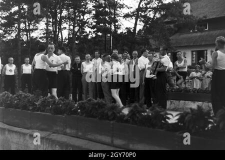 Musik und Tanz vor Waldhütten des KdF Sportheim Belzig in der Mark Brandenburg, Deutschland 1930er Jahre. La gente di cantare e ballare nella parte anteriore dei rifugi forestali presso il club sportivo a Belzig nel Brandeburgo, Germania 1930s. Foto Stock