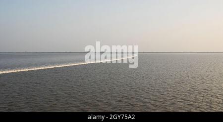 La marea si trova sull'estuario del fiume Qiantang. Riva settentrionale del fiume Qiantang vicino Hangzhou nella provincia di Zhejiang, Cina. Foto Stock