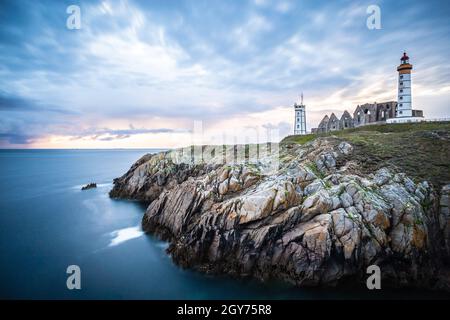 Le rovine dell'abbazia di Saint-Mathieu de Fine-Terre e il faro al tramonto, Finisterre, Bretagna Francia Foto Stock