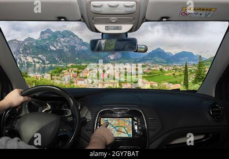 Guidare un'auto utilizzando il touch screen di un sistema di navigazione GPS verso Riva del Garda, Lago di Garda settentrionale, Trento, Italia Foto Stock