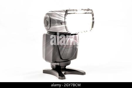Vista obliqua di un'unità flash esterna nera senza marchio per la fotocamera DSLR durante le riprese Foto Stock