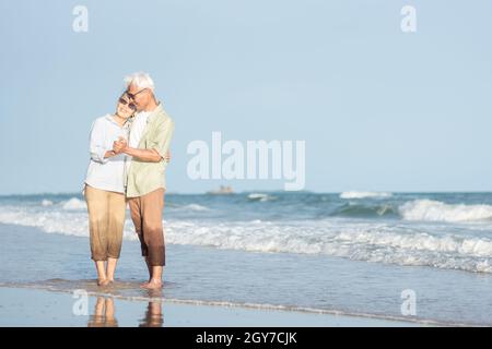 Felice asiatico anziano uomo e donna coppia sorriso danzare riposo relax sulla spiaggia luna di miele famiglia soleggiato giorno, anziani romantici godere di viaggio vacanza estiva Foto Stock