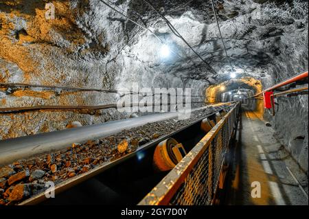 Trasportatore a nastro in un tunnel sotterraneo. Trasporto di minerale alla superficie Foto Stock