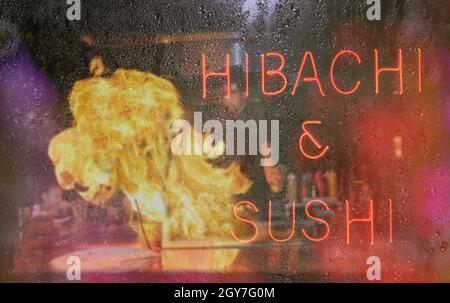 Hibachi e Sushi Neon segno con Chef in background, Blur Rainy finestra immagine Foto Stock