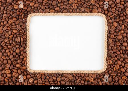 Cornice in corda con chicchi di caffè e sfondo bianco, con spazio per il testo Foto Stock