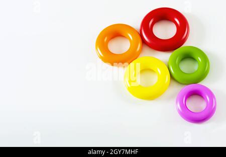 un gruppo di cinque colorati anelli di plastica isolati su uno sfondo bianco. Giocattoli per bambini. Stesse dimensioni per ciascun anello Foto Stock