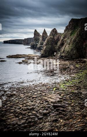 L'aspra e desolata bellezza della natura che ha formato gli Stacks fuori dalla scogliera a Duncansby Head sulla costa nord delle Highlands scozzesi Foto Stock