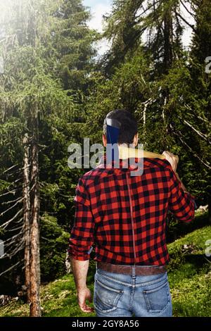 Lumberjack da dietro a piedi verso la foresta. Foto Stock