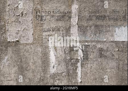 Marrone grunge sfondo astratto trama di una superficie da un vecchio cartellone intemperato con resti di carta strappata ads, spazio copia Foto Stock