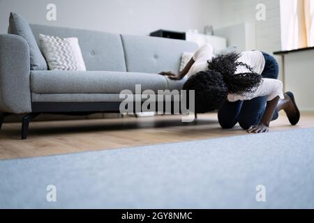 African Woman perso chiave o telefono. Ricerca di qualcosa Foto Stock