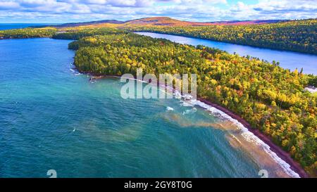 Penisola dell'isola con un lago o un oceano su entrambi i lati e una foresta di caduta con alberi di arancio, verde, rosso e giallo Foto Stock