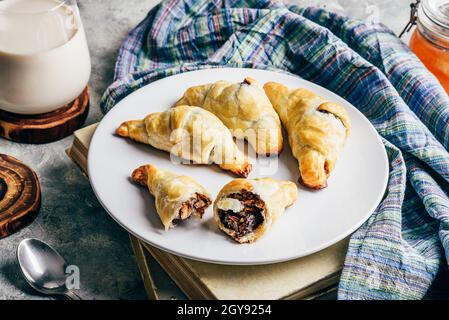 Croissant al cioccolato appena sfornati con latte per colazione Foto Stock