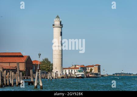 Antico faro dell'isola di Murano, famoso per la produzione del vetro artistico, con la stazione di Vaporetto chiamata Murano Punta Faro, Venezia, Italia. Foto Stock