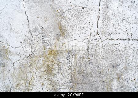 Vecchio muro di cemento con crepe e distruzione naturale a causa del tempo e delle condizioni atmosferiche. Può essere utilizzato come sfondo. Foto Stock