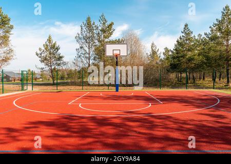 Un campo da pallacanestro vuoto trovato all'aperto durante la primavera stagione Foto Stock