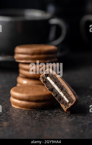 Biscotti con glassa di cioccolato su tavola nera. Foto Stock