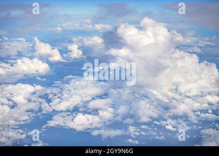 Soffici nuvole di cielo illuminate dal sole del pomeriggio, come visto da un aereo commerciale che vola sopra. Foto Stock