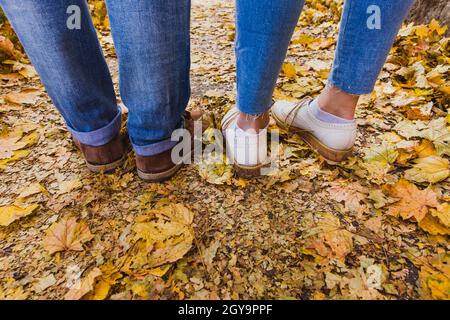 Stivali da uomo e uomo su foglie di autunno secco nel parco naturale all'aperto e la stagione autunnale Foto Stock
