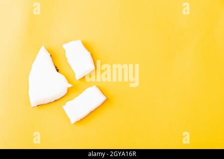 Happy Coconuts giorno concetto, fresco noce di cocco pezzi gruppo fette, studio girato isolato su sfondo giallo Foto Stock