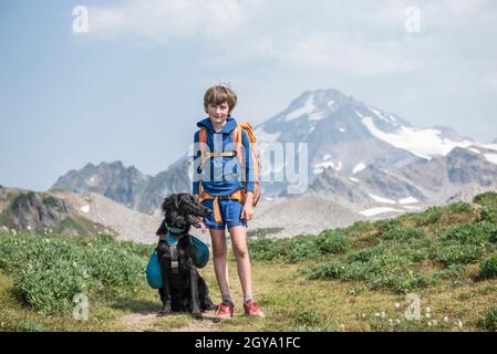 Un ragazzo ed il suo cane che camminano in Glacier Peak Wilderness. Foto Stock
