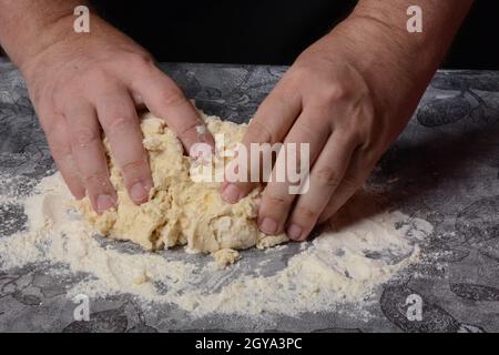 Processo di produzione di pasta fatta in casa per gnocchi, ravioli o pelmeni con carne macinata. Foto Stock