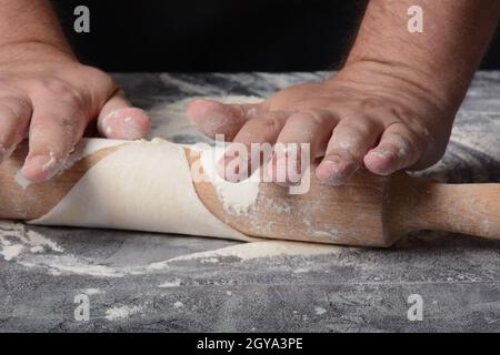 Processo di produzione di pasta fatta in casa per gnocchi, ravioli o pelmeni con carne macinata. Foto Stock