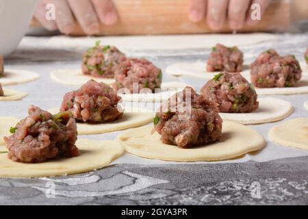 Processo di produzione di gnocchi fatti in casa, ravioli o pelmeni con carne macinata. Foto Stock
