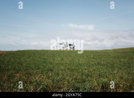 Camper solo in un grande campo verde aperto in Inghilterra Foto Stock