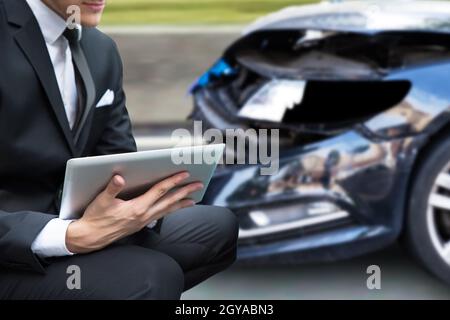 Agente assicurativo o ricercatore. Rapporto di reclamo per incidente auto sul tablet Foto Stock