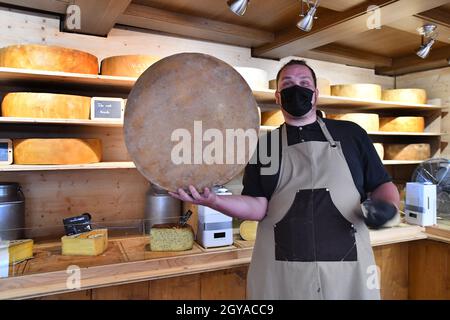 Caseificio artigianale che taglia formaggi tradizionali fatti a mano a Ribeauvillé, Alsazia, Francia Foto Stock