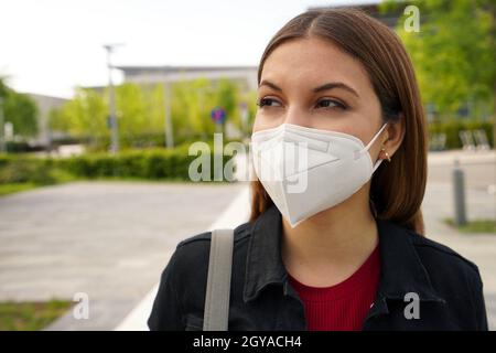 Maschera protettiva FFP2. Primo piano di una giovane donna che indossa una maschera medica per la strada come prevenzione e protezione. Foto Stock