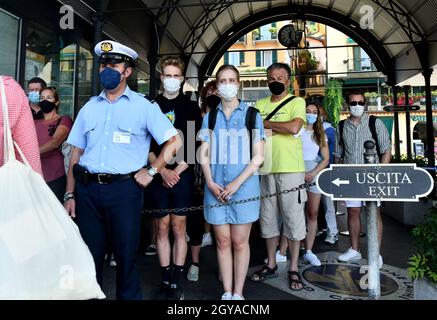 I passeggeri che indossano le maschere facciali Covid 19 pandemiche mentre aspettano di salire a bordo della barca sul lago di Como, Italia Foto Stock